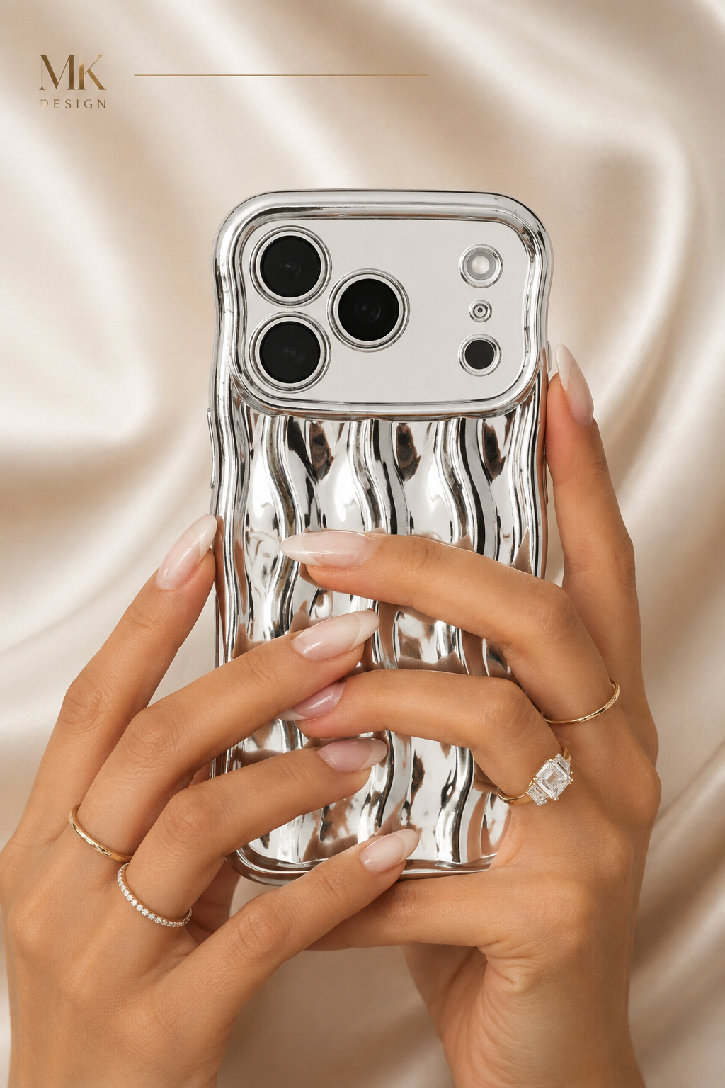 Silbernes iPhone in einer Hand vor hellem Stoff